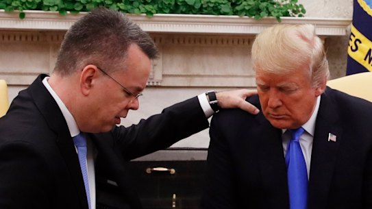 US President Donald Trump prays with American pastor Andrew Brunson in the Oval Office of the White House, on Saturday.