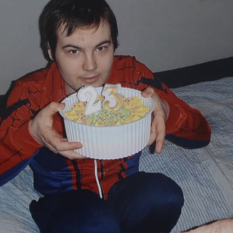 Reece Parkinson sits on his mattress in the room where he spends most of his time on his recent birthday.