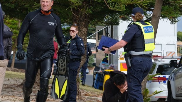 The distraught family of a snorkeller who went missing near the pier on Altona beach look on as the search and rescue team resumed on Sunday. 