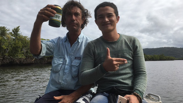A local fisherman (left) treating one of two suspected asylum seekers to a tour after he was found on the banks of the Daintree River.