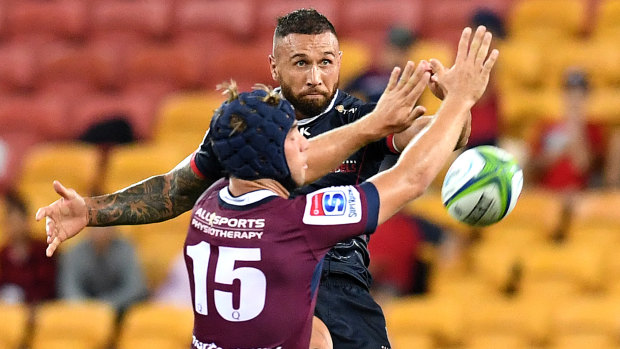 Prodigal son: Quade Cooper gets a kick away, past Hamish Stewart of the Reds at Suncorp Stadium.