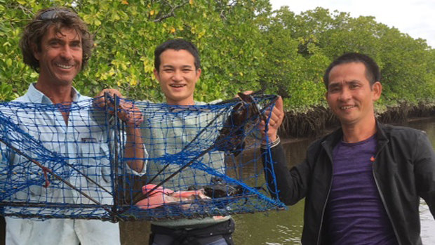 Local fisherman Justin Ward (left) with the two suspected asylum seekers on the Daintree River.