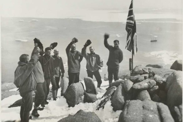 Sir Douglas Mawson and expedition members cheering the raising of the Union Jack flag at Proclamation Harbour, Enderby Land, Antarctica, ca. 1930.