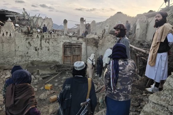 Afghans look at the destruction caused by an earthquake in the province of Paktika, eastern Afghanistan.