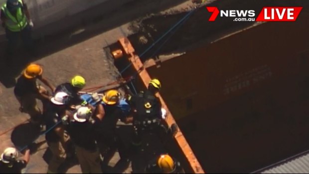 A man is being rescued after he fell six metres down a hole at a worksite in Brisbane.