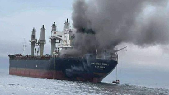 A Thai cargo vessel on fire in the Strait of Hormuz, reflecting the danger of Iranian attacks.