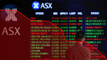A man stands in front of digital market boards at the Australian Stock Exchange (ASX) in Sydney, Monday, March 2, 2020. The Australian share market spiralled nearly 2.5 per cent lower as the deadly coronavirus spreads across the planet and stifles trading prospects. (AAP Image/Joel Carrett) NO ARCHIVING