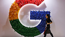 In this Monday, Nov. 5, 2018, file photo, a woman walks past the logo for Google at the China International Import Expo in Shanghai.