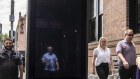 Pedestrians walk past a billboard in Crown Street, Darlinghurst, in Sydney.