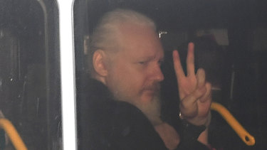 Julian Assange gestures as he arrives at Westminster Magistrates' Court in London.