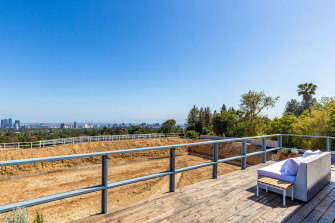 The listing has been styled with a single outdoor couch, to admire the view of downtown LA. 