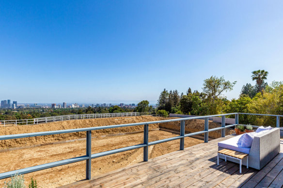 The listing has been styled with a single outdoor couch, to admire the view of downtown LA. 