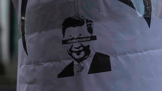 A placard featuring Chinese President Xi Jinping, is displayed near the Chinese embassy in London.