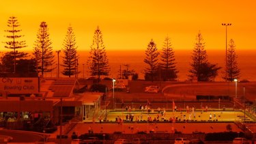 The fire above Port Macqurie turned orange and red on Friday night as bushfires tore through the area.