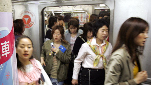 Women passengers get off a subway train at a Tokyo station.
