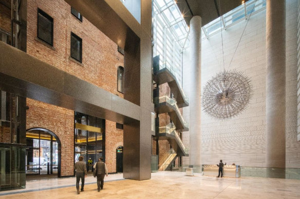 A soaring modern lobby fills the space immediately behind the 1889 brick facade of the Olderfleet building.