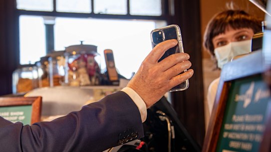 Premier Mark McGowan shows his proof of vaccination. 