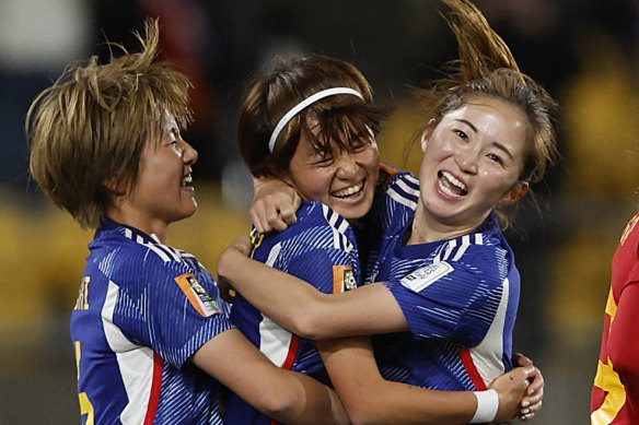 Japan celebrate after scoring their third goal against Spain.