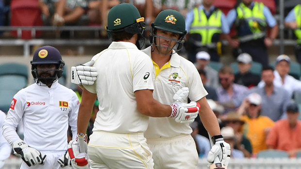 Australia's batsman Joe Burns hugs Travis Head after their 200-run partnership.