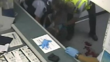The aftermath of the assault: Police mop up blood on the floor.