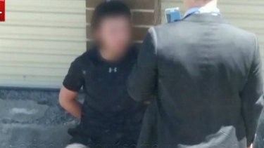 Police speaking to one of the arrested teenagers in Bankstown. 