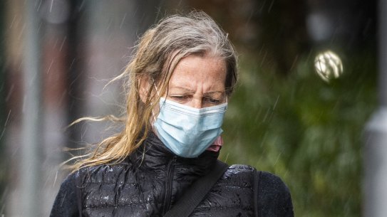 A Melbourne pedestrian is caught in the rain. The city’s lockdown has become the world’s longest.