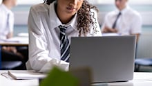 Stock image of a school student using a laptop