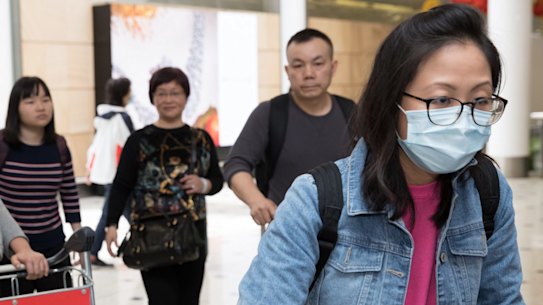 Passengers arrive at Sydney Airport wearing masks. 