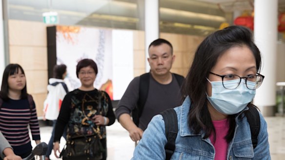 Passengers arrive at Sydney Airport wearing masks. 