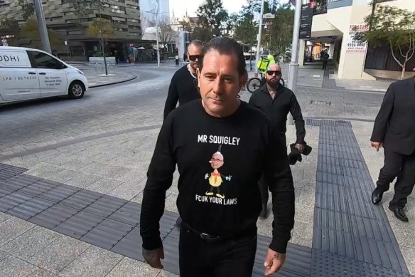 Troy Mercanti sporting a message for  Attorney General John Quigley on his way to a previous court appearance.