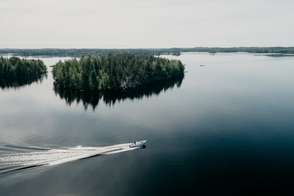 A boat tours the crystalline lake that surrounds the Sahanlahti Resort.