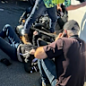Passers-by helped free a 46-year-old motorbike rider trapped under a car following the crash on Gympie Road.