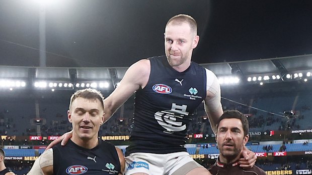 Sam Docherty of the Blues is chaired from the field after his final game by Patrick Cripps of the Blues (left) and Kade Simpson.