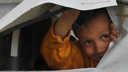 On the outside looking in: a child peeks through the flap of a tent in the foreign section of the al-Hawl camp in Syria.