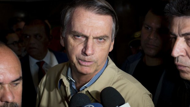 Presidential candidate Jair Bolsonaro, with the Social Liberal Party, talks to the press after visiting Federal Police headquarters in Rio de Janeiro,.