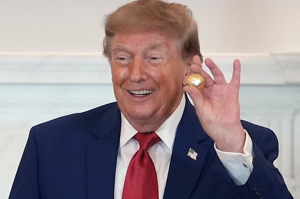 President Donald Trump holds a solid gold replica of a deep sea nodule he was gifted during a roundtable on American mining on Friday.