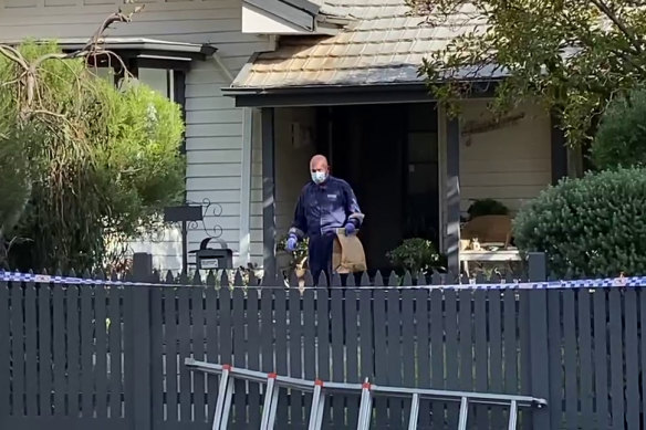 A police officer takes evidence from the house in Spotswood. 