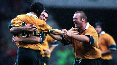 Joe Roff and Richard Harry swamp Stephen Larkham after his field goal in extra time won Australia's semi-final against South Africa in the 1999 World Cup.