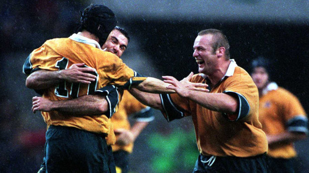 Joe Roff and Richard Harry swamp Stephen Larkham after his field goal in extra time won Australia's semi-final against South Africa in the 1999 World Cup.