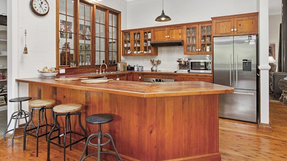 The circa 1970s kitchen featured heavy, pine-knotted joinery.