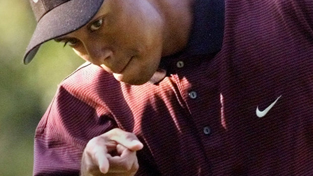 Tiger Woods points the ball into the hole in the 2000 PGA Championship.