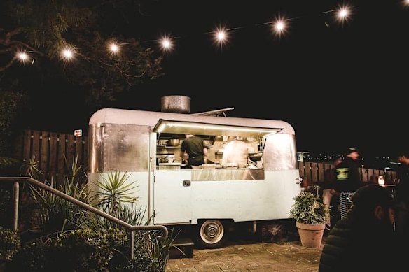 Food is served out of a retro caravan. 