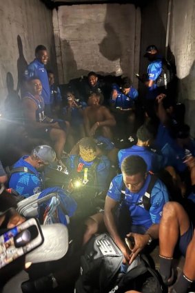 Fijian Drua players in the back of a luggage truck on their trip to New Zealand.