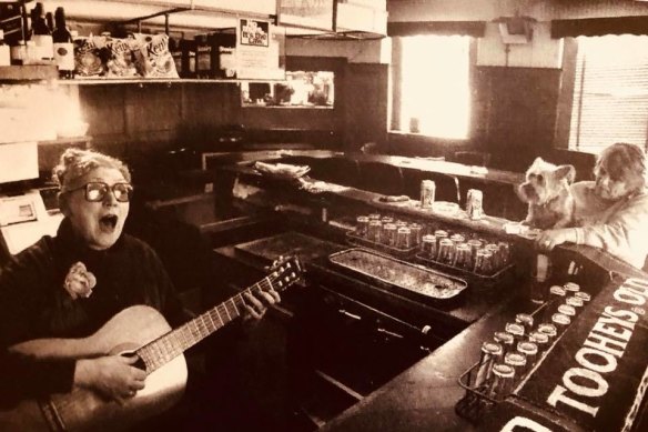 Doris Goddard plays guitar behind the bar at the Hollywood Hotel.