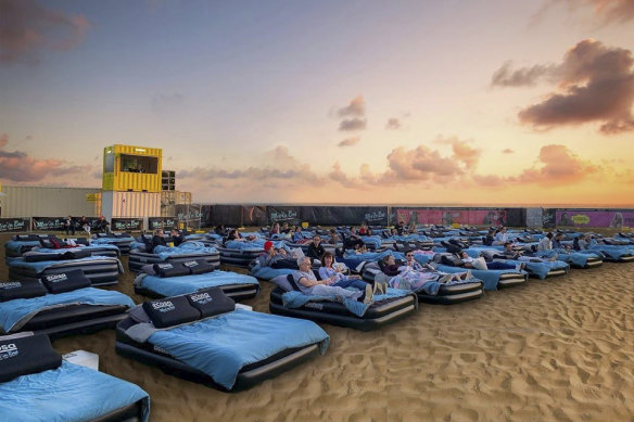 Beds, burgers, a bar and a big screen, on the beach.
