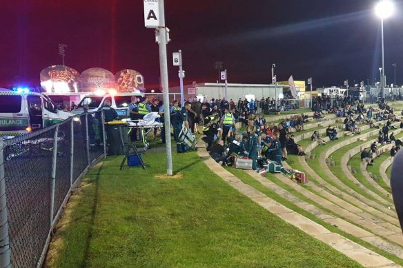 Ambulance officers provide first aid to Nick Martin and Ricky Chapman after the Perth Motorplex shooting.