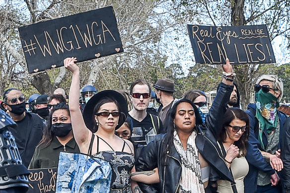 An anti-lockdown protester in Melbourne’s Albert Park in September holds a sign referring to the QAnon slogan “Where We Go One, We Go All”.