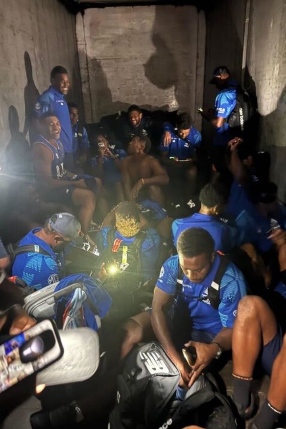 Fijian Drua players in the back of a luggage truck on their trip to New Zealand.