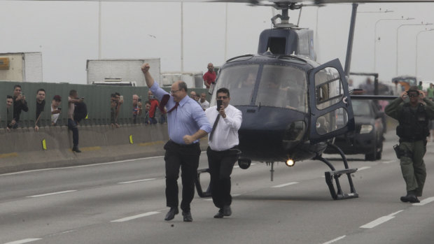 Rio de Janeiro Governor Wilson Witzel pumps his fist after arriving on a helicopter.