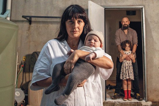 Karri Crossing and Hayden Muirhead  with one-week-old baby Ziggy and daughter Juno; Lismore after the flood peaked on February 28; A Lismore street, days later; A warning sign on a fence of a home along the river in Woodburn.